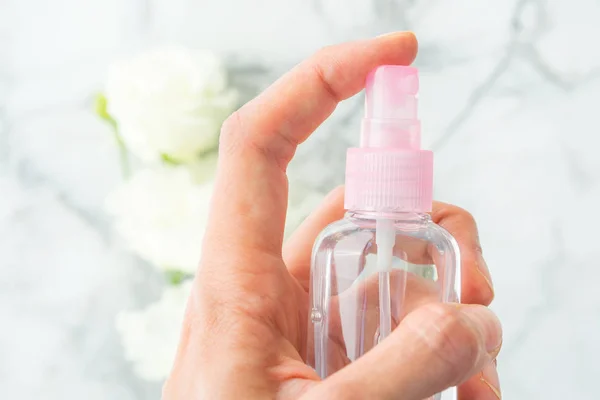 Womans hand spritzing vätska från spray — Stockfoto