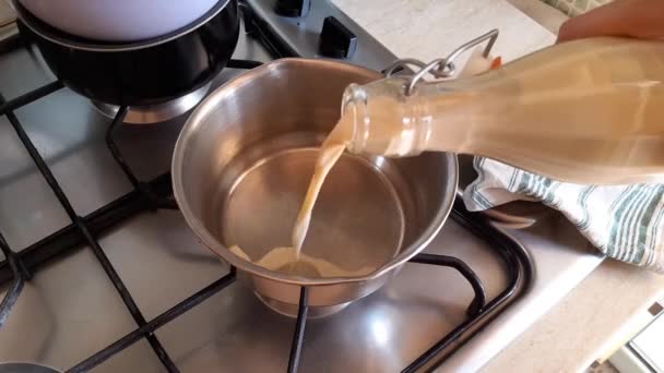 Χύνοντας στο σπίτι φτιαγμένο φυτικό γάλα σε ένα τηγάνι — Αρχείο Βίντεο