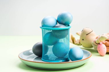 Pastel yeşil arka plan üzerinde mavi paskalya yumurtaları