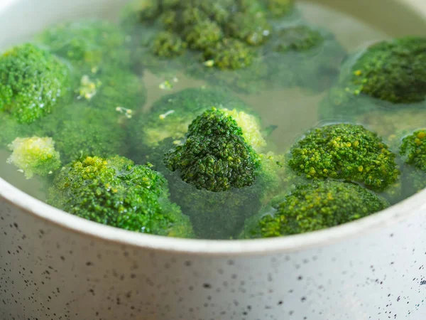 Matlagning broccoli i vatten i en kastrull — Stockfoto