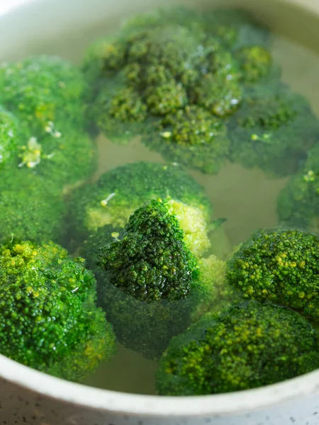 Koka broccoli i vatten i en kastrull. Närbild — Stockfoto