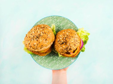 Hecelenmiş çöreklerle vejetaryen sebze burgeri.