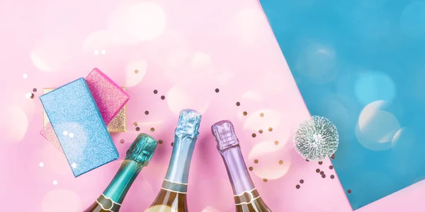 Bouteilles de champagne, cadeaux et confettis sur rose — Photo