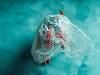 Oyuncak dinozor plastik pakette turkuaz üzerinde