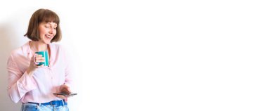 Kadın kahve içiyor ve akıllı telefon kullanıyor.