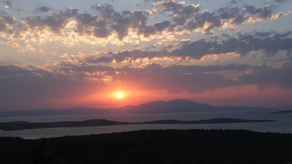 Gün batımında dağların arkasında oluşan muhteşem ışık ve bulutlar.