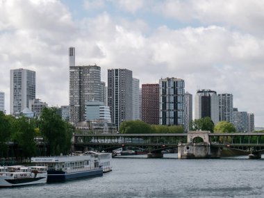 Paris, Fransa 'daki Seine nehrinin kıyısındaki modern binalar. Nehrin üzerindeki eski köprü..