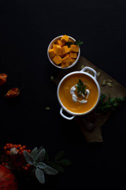 Tohumlu, baharatlı ve koyu renkli otlu ev yapımı balkabağı kreması çorbası. Sağlıklı ve vejetaryen gıda kavramı.