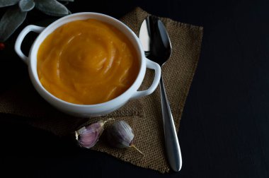 Tohumlu, baharatlı ve koyu renkli otlu ev yapımı balkabağı kreması çorbası. Sağlıklı ve vejetaryen gıda kavramı.