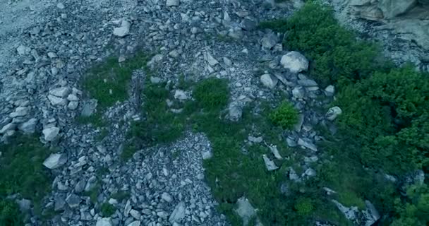 ドローンは山の近くの岩峰の周りを空中から眺め そこに石の山が示されています — ストック動画