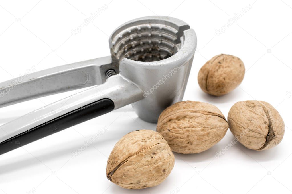 Walnuts on a white background, broken by a nutcracker