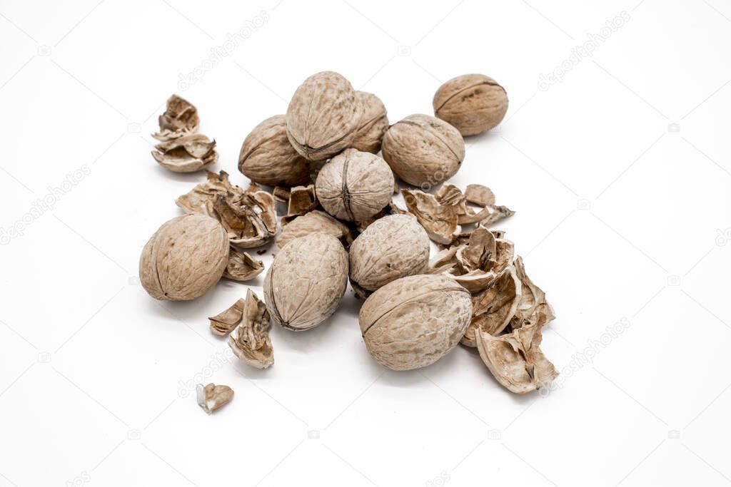 Walnuts on a white background, broken by a nutcracker