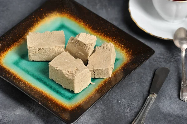 Halva Cortado Fatias Uma Chapa Chá Uma Caneca Fundo Escuro — Fotografia de Stock