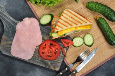 Marul, jambon, yumurta ve domates ile sandviç ekmeği üstten görünüm koyu arka plan üzerinde