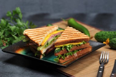 jambon ve omlet rustik koyu arka plan üzerinde bir plaka üzerinde üçgen şekilli sandviçler