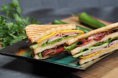 jambon ve omlet rustik koyu arka plan üzerinde bir plaka üzerinde üçgen şekilli sandviçler