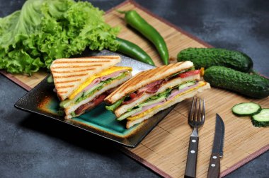 Preslenmiş ve jambon ve omlet rustik koyu arka plan üzerinde bir tabakta sandviçler tost Çift Kişilik panini - üçgen şeklinde