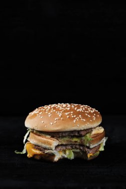 rustik koyu arka plan üzerinde ısırıldı burger