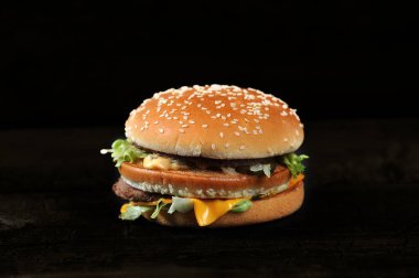 Siyah arka planda taze lezzetli bir burger.