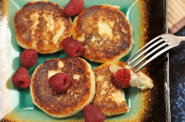 Cheesecakes veya taze ahududu ve ahududu reçeli closeup ile peynirli gözleme