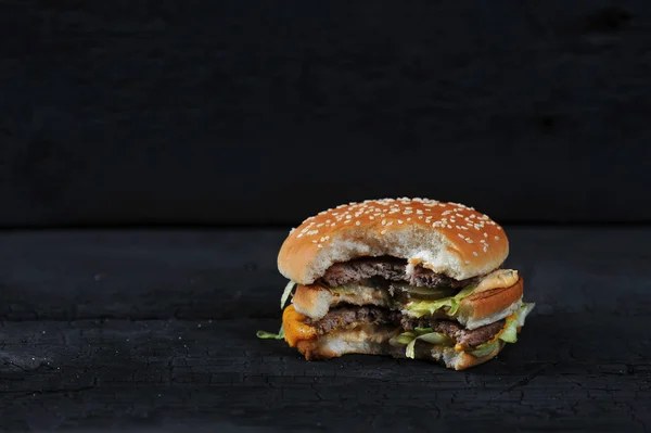 bitten burger on a dark rustic background