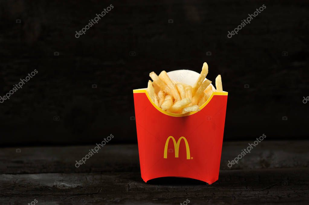 St.Petersburg, Russia - 12 August 2018: McDonald's meal on rutic black background, includes French Fries potato
