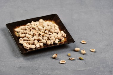 bir koyu gri arka plan üzerine bir kase fıstık