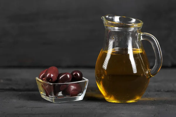 olives, olive oil in glass containers-on a dark background with space for text