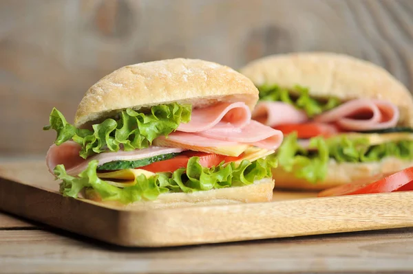 ham and cheese sandwiches on wooden Board - on wooden background