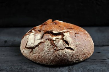 çavdar ekmeği, siyah rustik arka planda - yan görünüm tüm somun