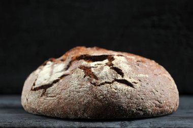 Çavdar ekmeği, koyu kırsal arka planda bir somun ekmek.
