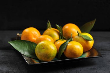 mandalina boşaltmak rustik siyah zemin üzerine yeşil yaprak