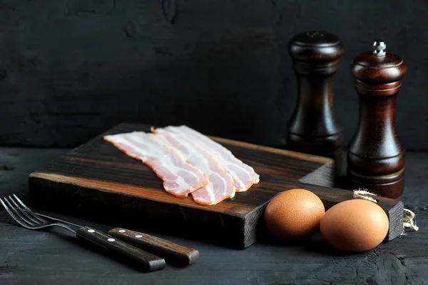 Tocino Sobre Tabla Madera Huevos Cubiertos Sobre Fondo Negro — Foto de Stock