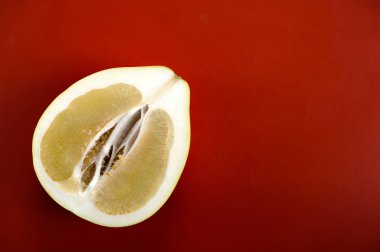 yarım bir pomelo üzerinde kırmızı bir arka plan - üstten görünüm