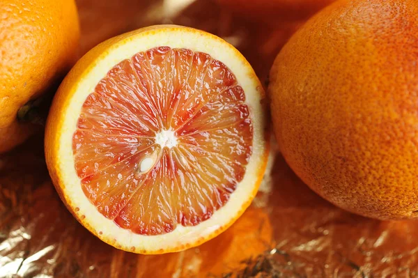 Rode sinaasappelen op goud folie — Stockfoto