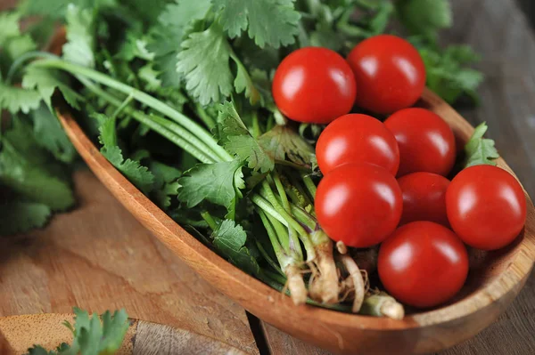 Tomates e coentro em uma placa de madeira o — Fotografia de Stock