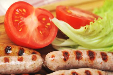 ızgara füme sosis, marul yaprağı, domates. Yakın çekim.