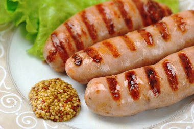 Kızarmış sosis ve salata yaprakları ve biberli ızgara sosis.