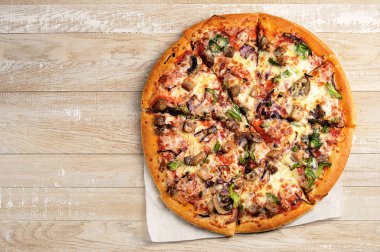 Yuvarlak pizza ahşap bir arka planda parçalara bölünmüş - üst görünüm - boşluğu kopyala