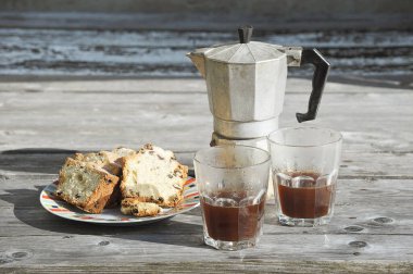 Sabah kahvesi - kahve demliği ve kaba ahşap arka planda kekli iki bardak kahve.