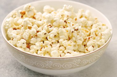 Gri arka planda bir tabakta patlamış mısır