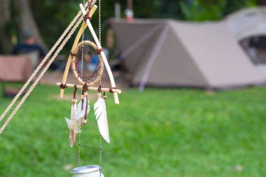 Kamp alanındaki yeşil çimenlikteki çadırların bulanık arka planına sahip klasik Düş Yakalayıcı 'ya odaklan.