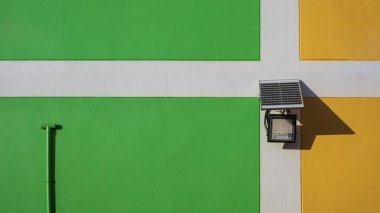 Renkli bina duvarında havalandırma borusu olan küçük güneş pili paneli