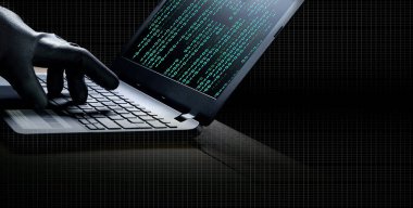 Siyah eldivenli hacker el kolajı. Bilgisayarı kullanarak bilgisayar sistemini hacklemek. Masanın üzerinde ikili kod var.