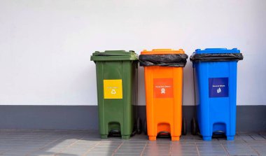 Çok renkli üç çöp bidonu kaldırım kiremitleri zemin ve kamu alanındaki beton duvar zeminleri