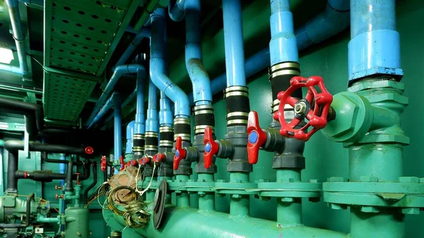 Focus on red gate valve on foreground with pipelines of main water pressure control in engine room area of fishing vessel — Stock Image Focus Red Gate Valve Foreground Pipelines Main Water Pressure Control Royalty Free Stock Photos