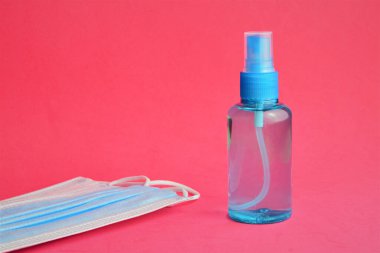 Yakın plan, hijyenik önlemler, hidroterapi jeli ve cerrahi maskeler, kırmızı arka plan.