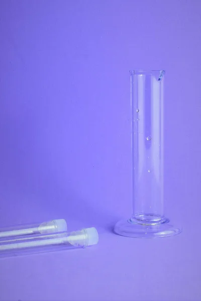 Chemistry laboratory instruments, specimen and test tubes, on blue background