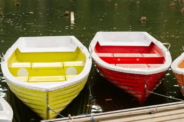 Kleurrijke boten aangemeerd aan de rand van een bergmeer tijdens de herfst seizoen. Nationaal park reis . — Stockfoto