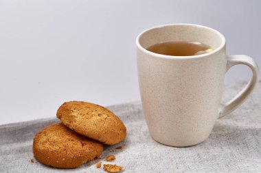 Beyaz porselen kupa çay ve tatlı kurabiye beyaz arka plan, üstten görünüm, seçici odak saf peçete üzerinde